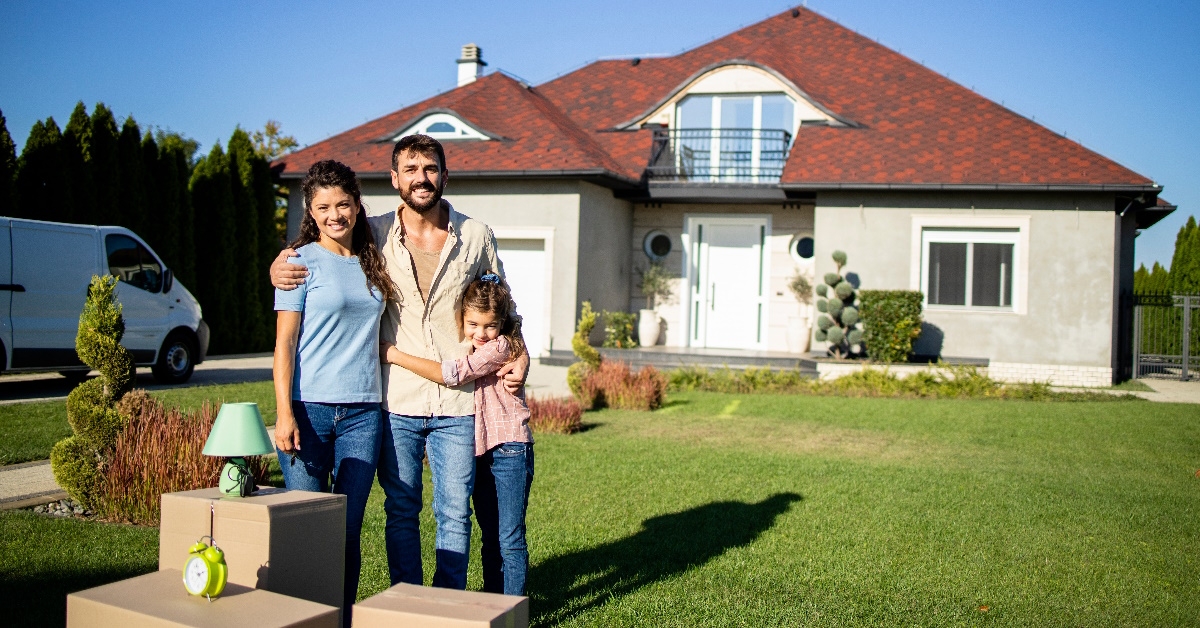 happy family posing outside new house