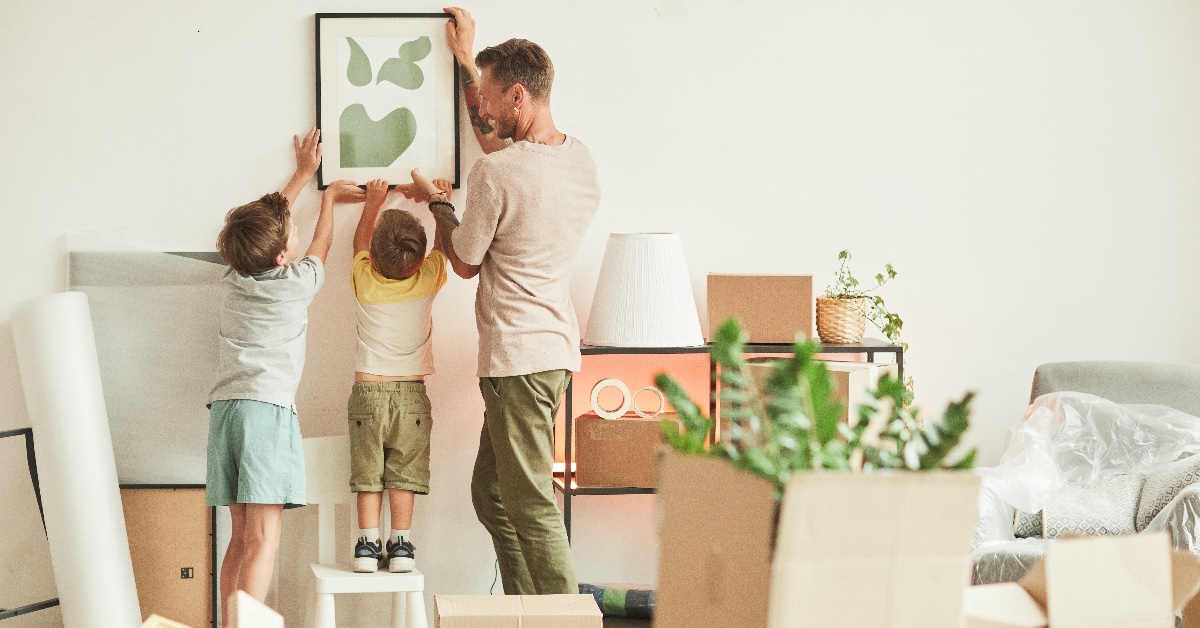 kids hanging paintings with father
