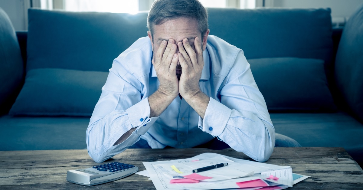 Man is under stress while making bill payments.
