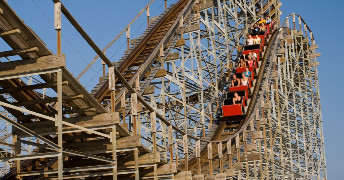 people riding old wooden roller coaster