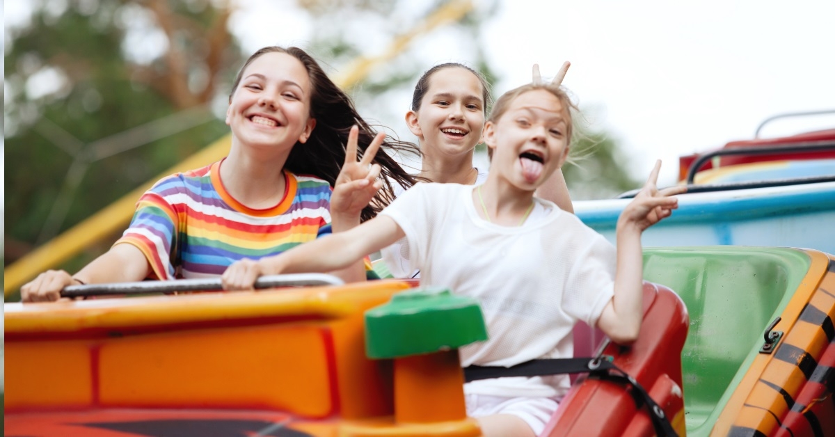 teenage girls enjoying roller coaster ride