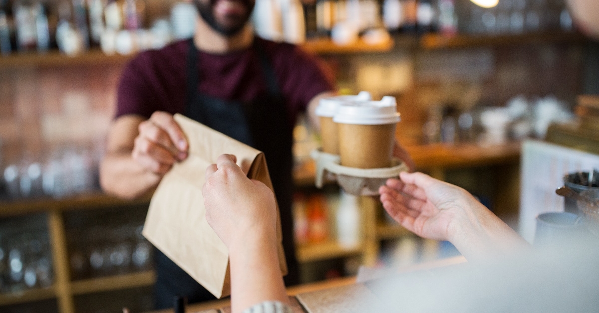bartender serving customer at coffee shop.