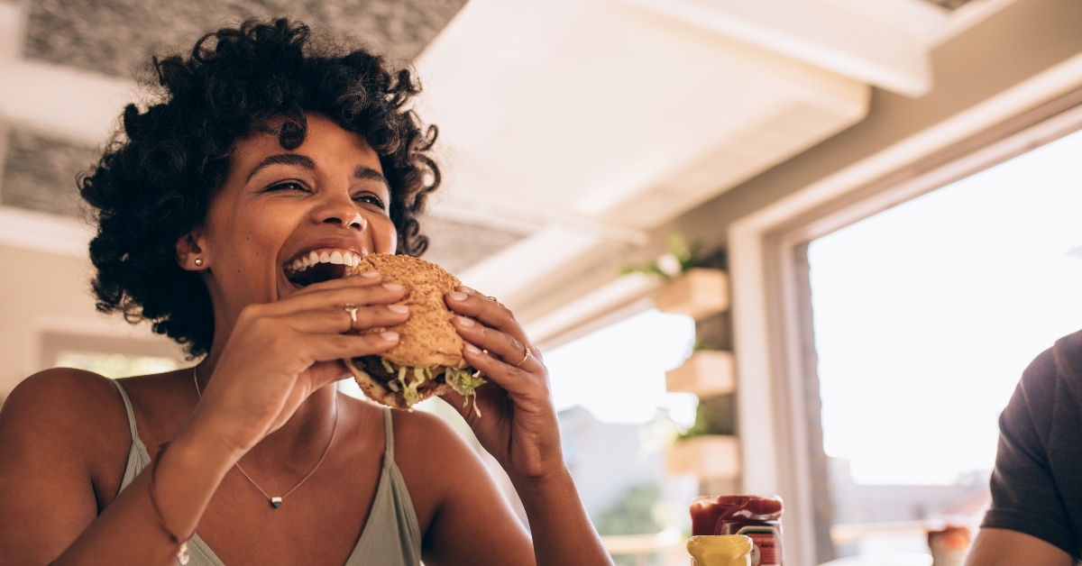 woman enjoying eating burger