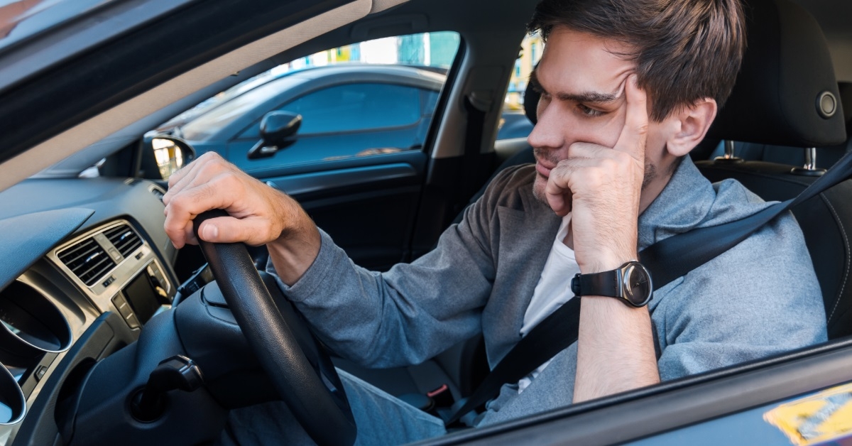 annoyed man driving car in traffic