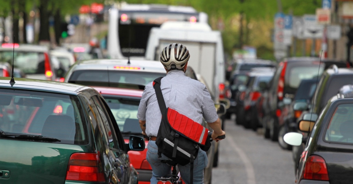 man on bicycle in traffic jam
