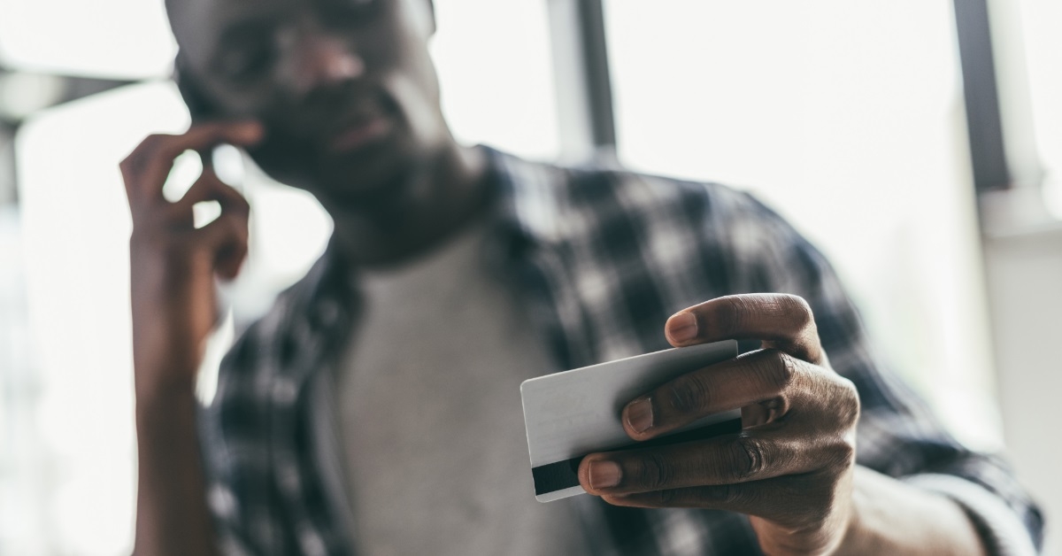 man holding card while on call
