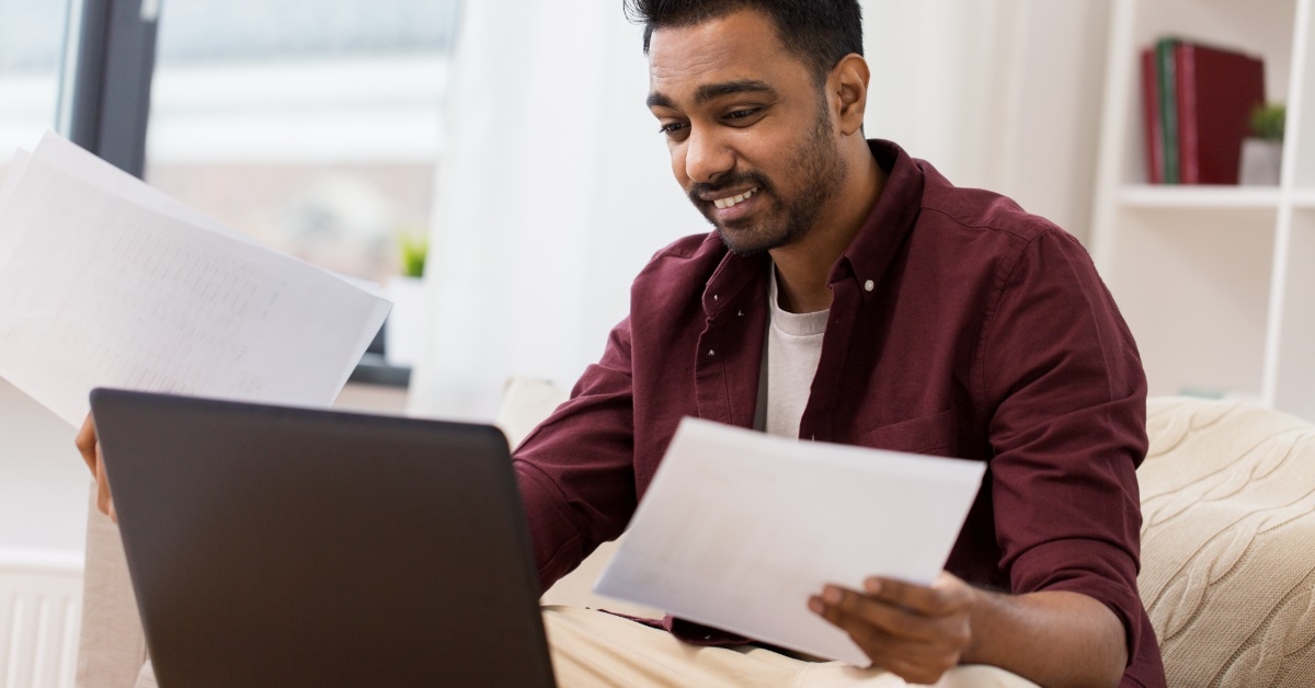 confused man with laptop and papers