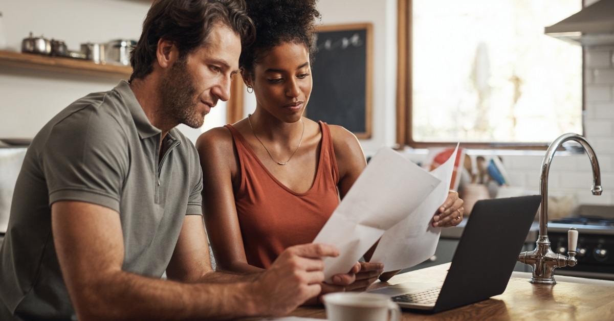 couple reviewing debt while using laptop
