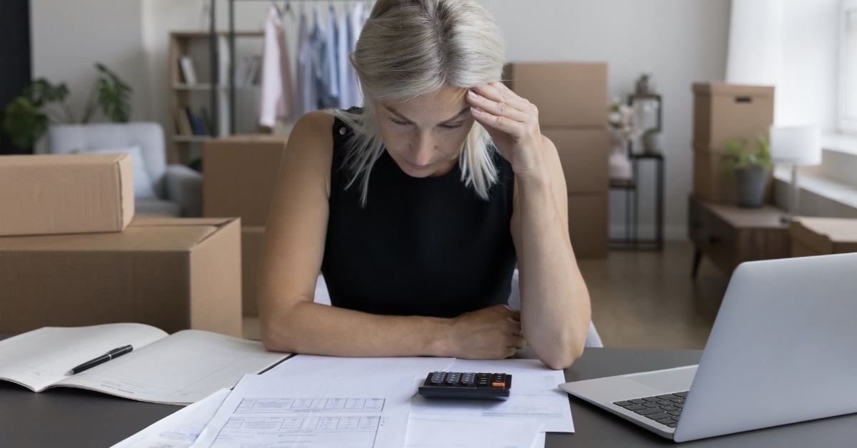 senior businesswoman stressing while reviewing bills