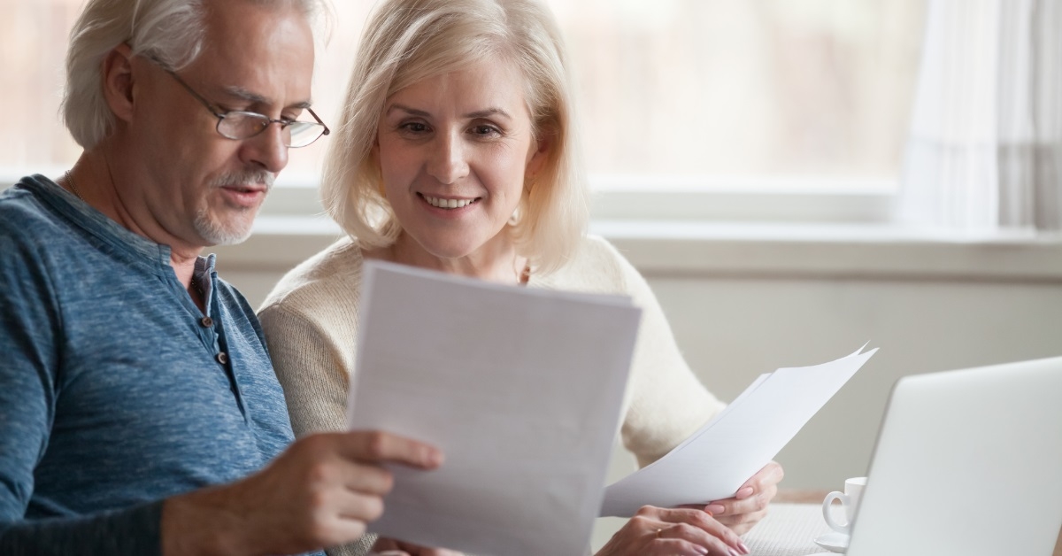 senior couple reviewing bills using laptop