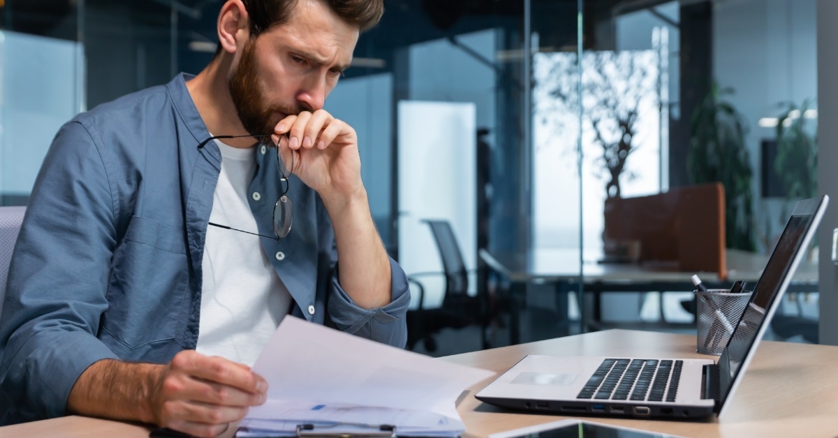 stressed businessman reviewing bills at office
