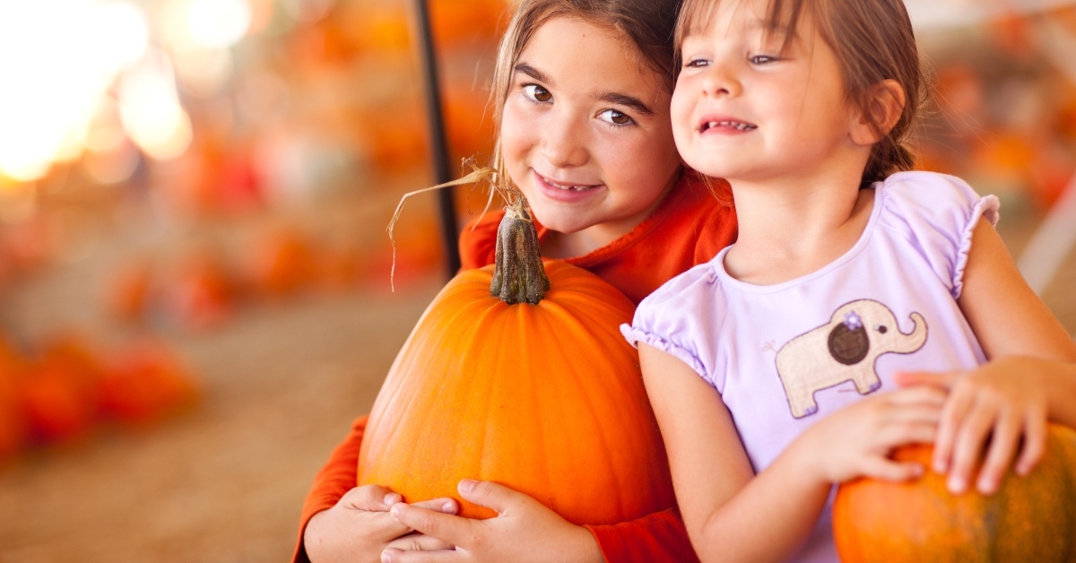 adorable little girls holding pumpkins