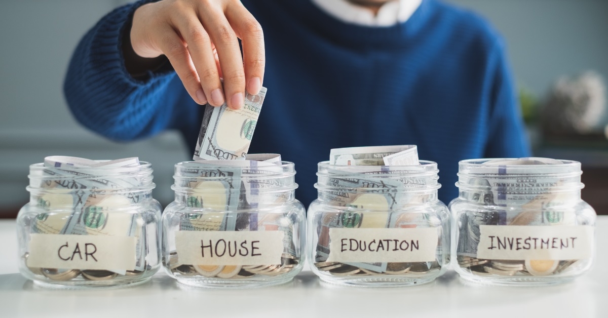 man saving money in glass jars