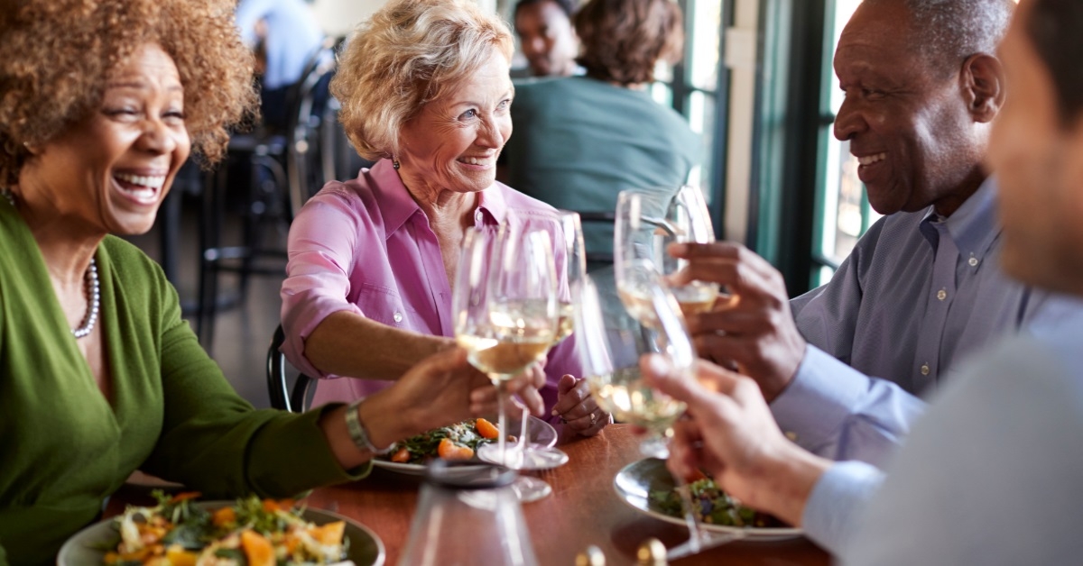 smiling senior friends meeting for meal