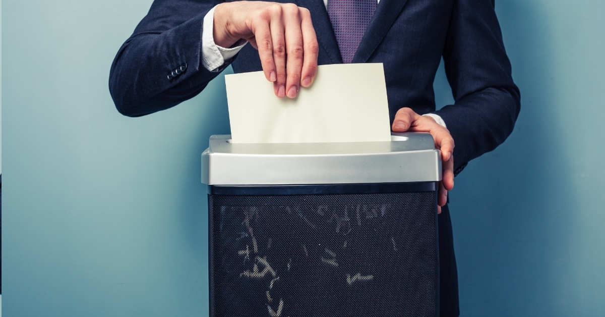 businessman shredding documents in machine