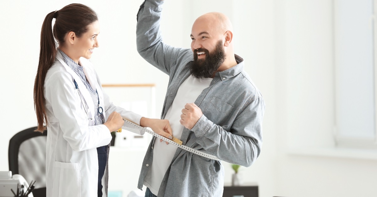 female doctor measuring waist of client