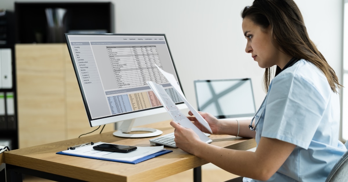 female doctor reviewing bills and spreadsheets