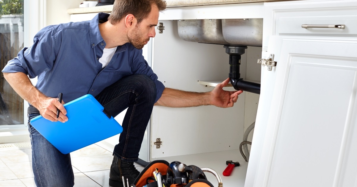 male plumber repairing kitchen sink