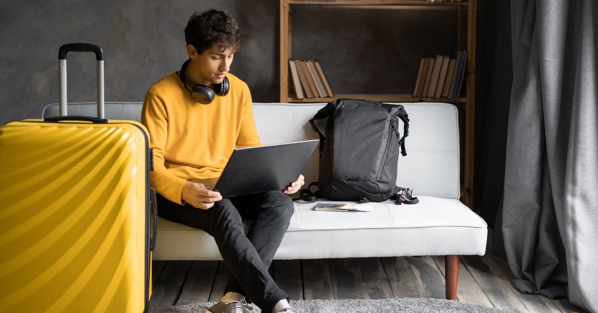 young boy booking vacation using laptop