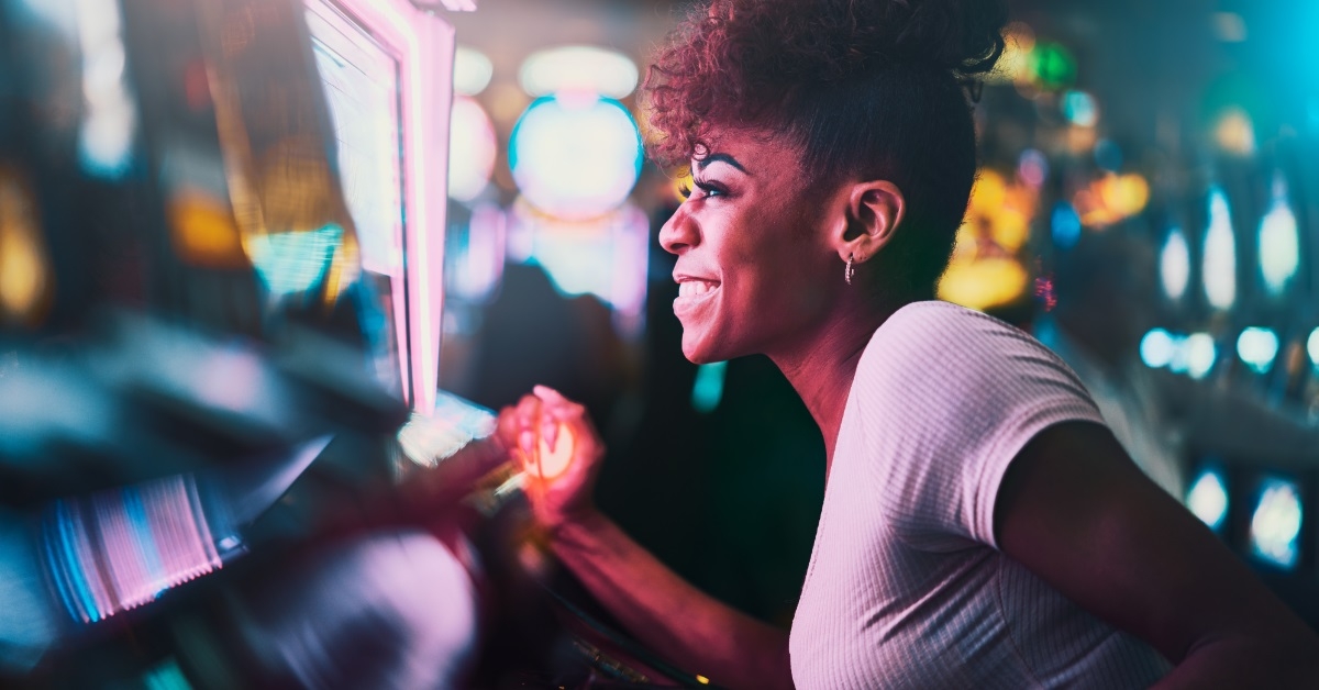 african woman playing casino slot machine