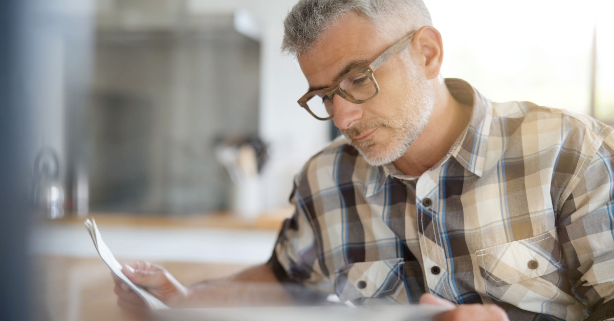 man in kitchen reading newspaper