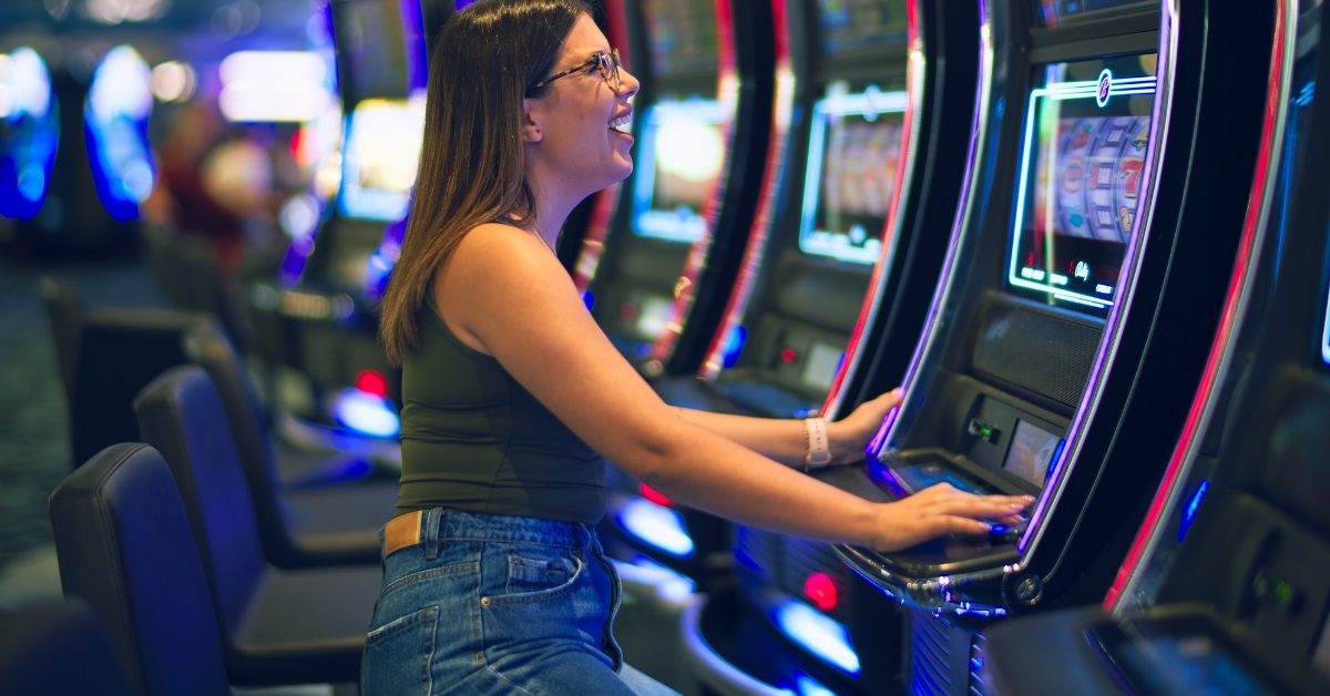 woman playing slot machine at casino