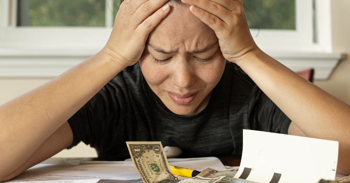 asian woman stressed at bills