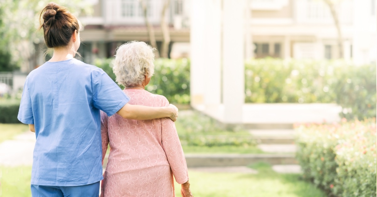 nurse giving support to senior woman