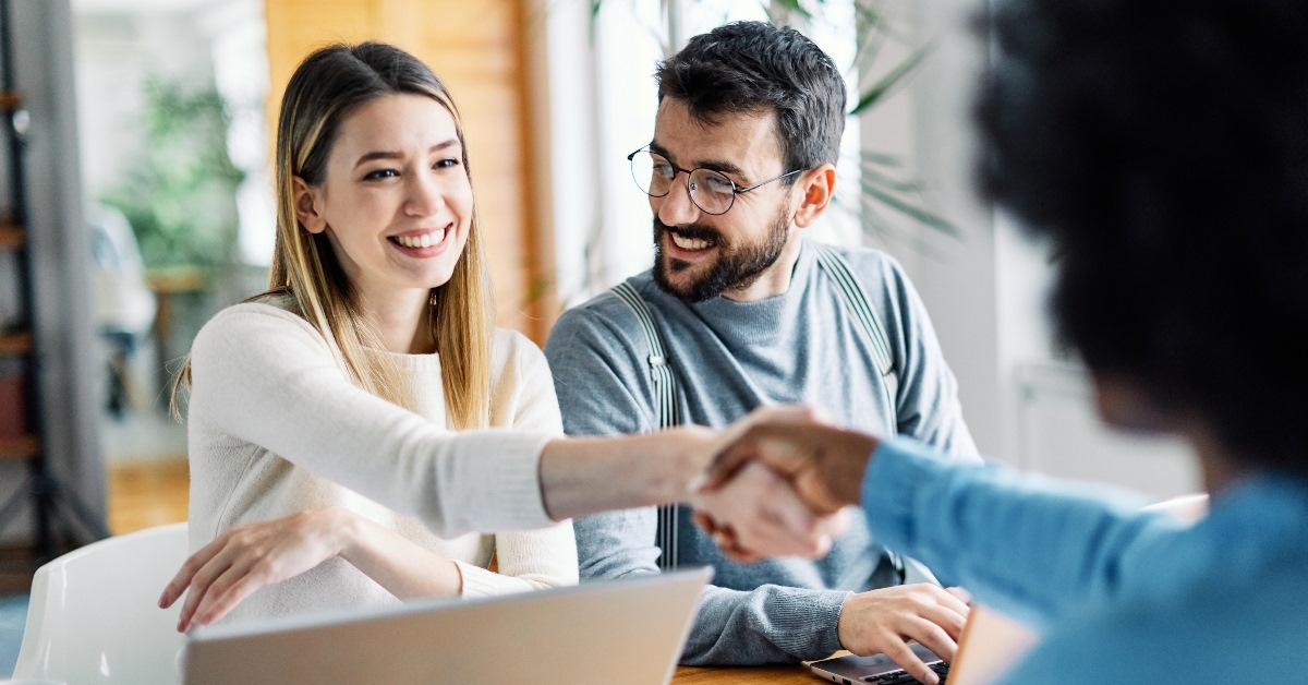 couple shaking hands with finance advisor
