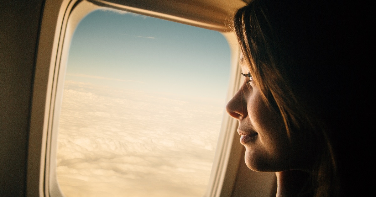 woman looking through airplane window