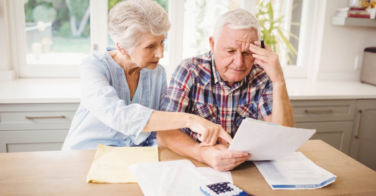 stressed senior couple reviewing bills
