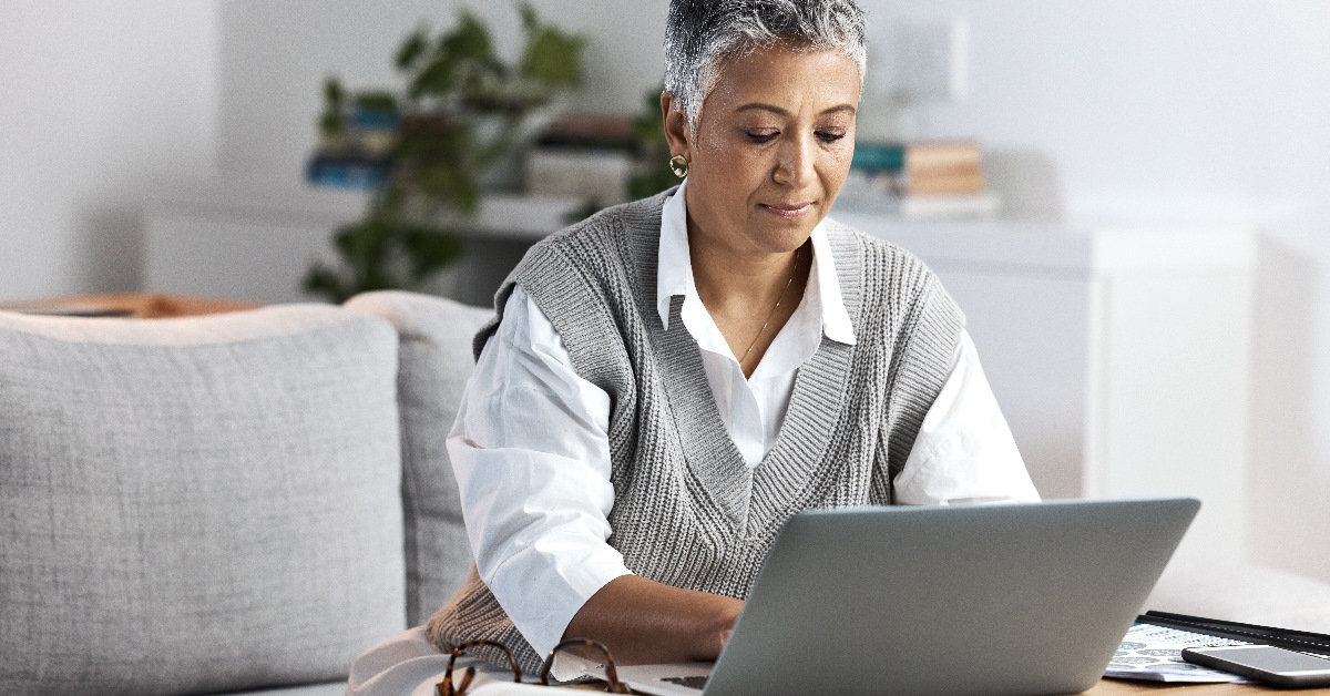 old woman working remotely from home office.