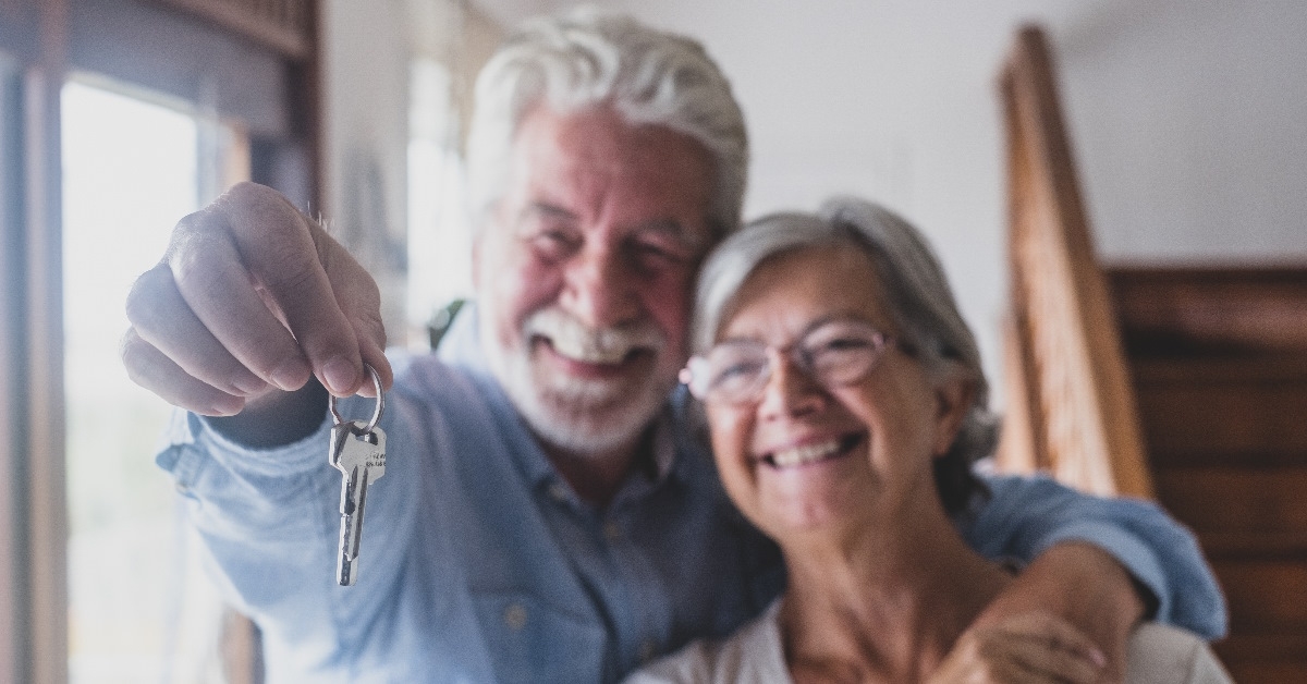 senior couple holding keys of their apartment.