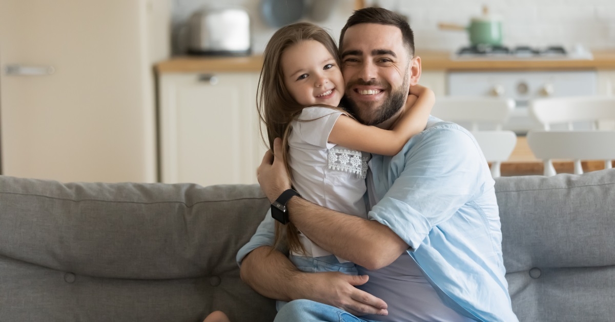 father hugging daughter at home