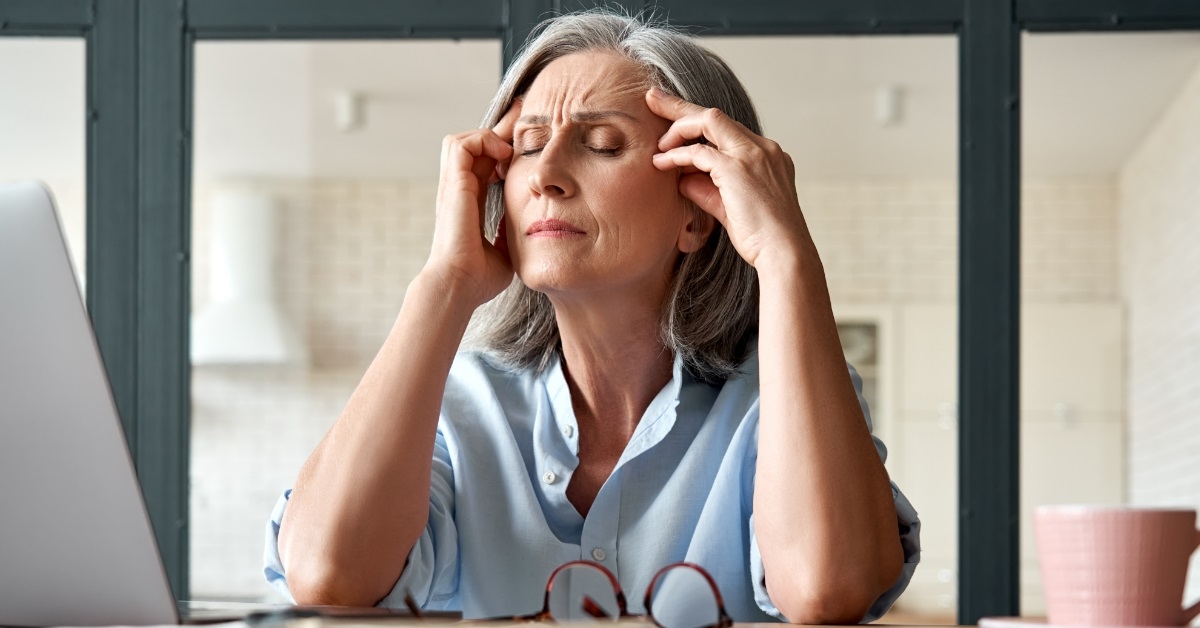 senior business woman suffering from headache