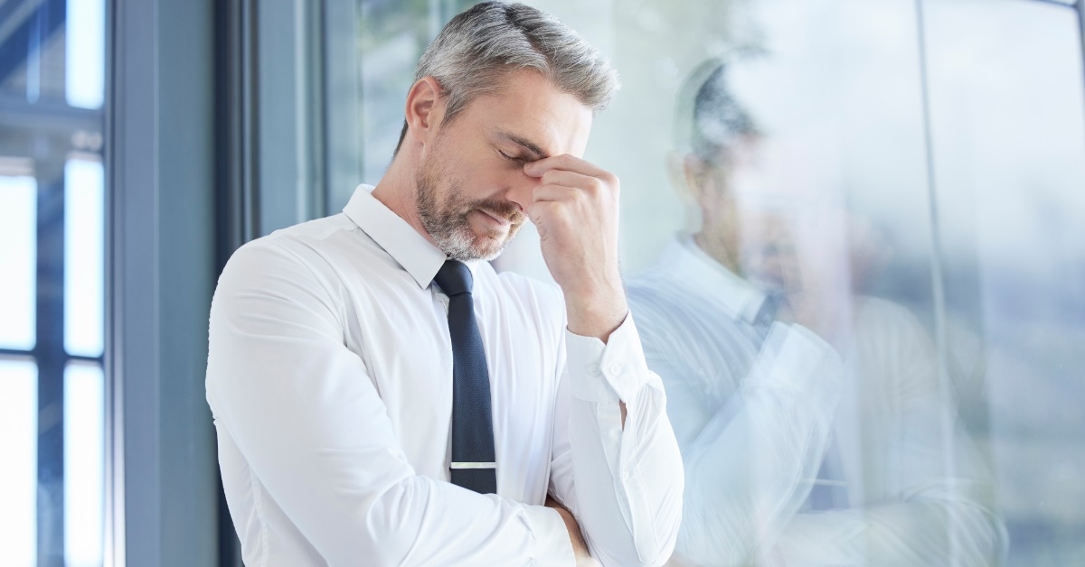 businessman stressed besides window at office