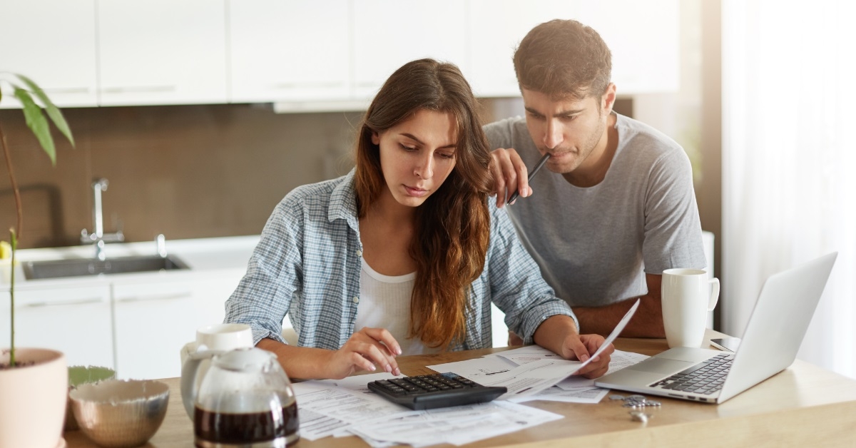couple reviewing bills at home kitchen