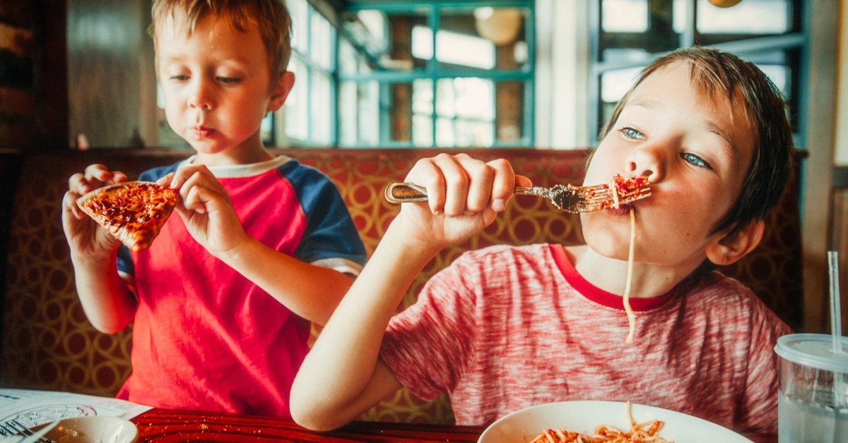 kids eat pizza and pasta at cafe