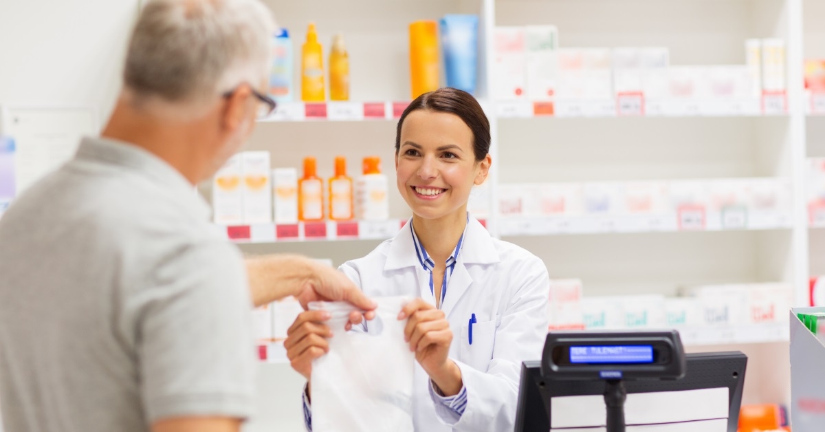 female pharmacist giving medicines to man