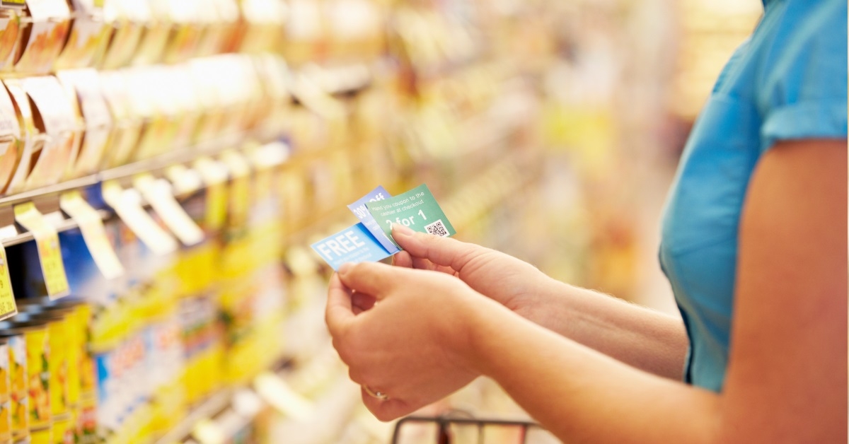 woman holding coupons in grocery aisle