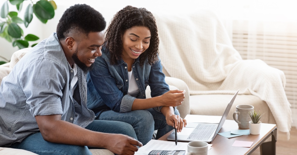happy african american couple reviewing bills