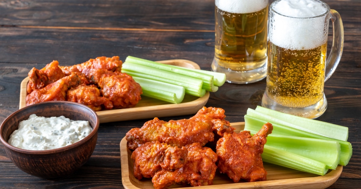 buffalo wings with mugs of beer