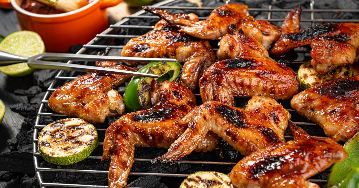chicken wings and vegetables on grill