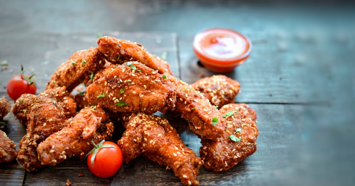 garnished chicken wings on wooden table