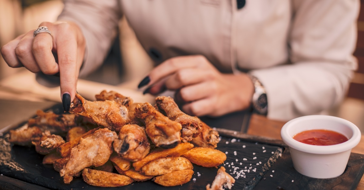 girl eating chicken wings at restaurant
