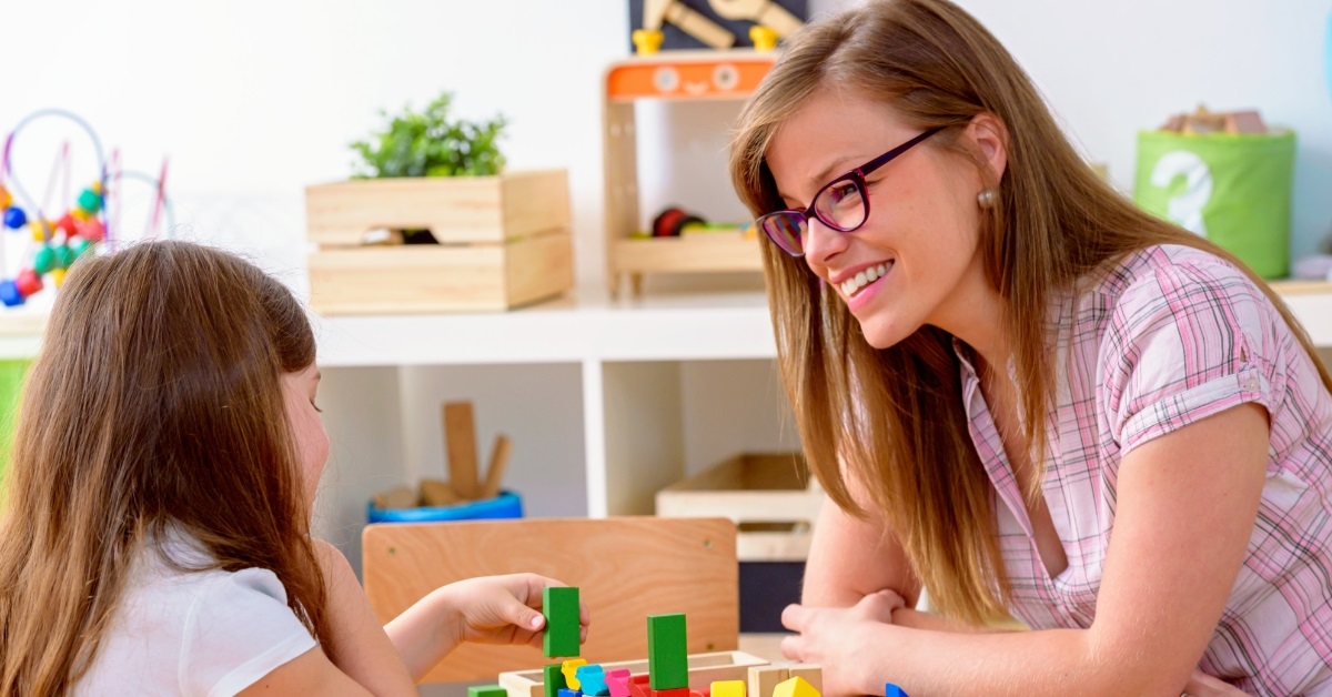 young teacher interacting with girl