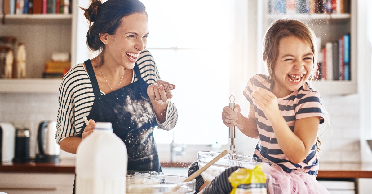 Mother and daughter having fun baking in kitchen.