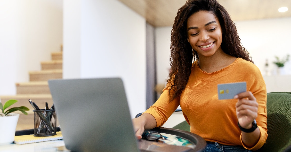 A lady is clutching a debit card for online shopping.