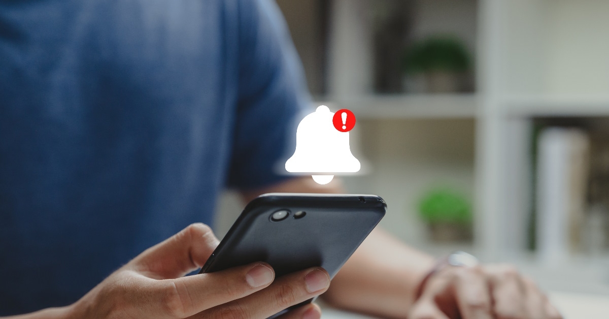 Man using his phone when he gets a danger notification.