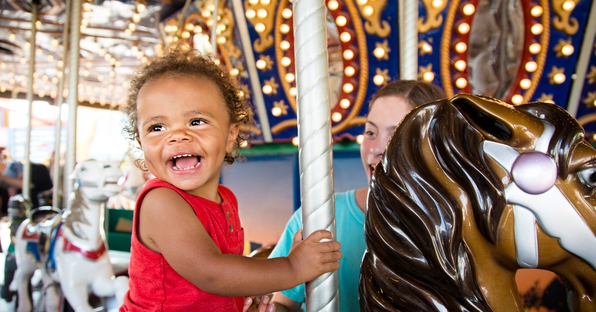 african american boy enjoying carousel ride
